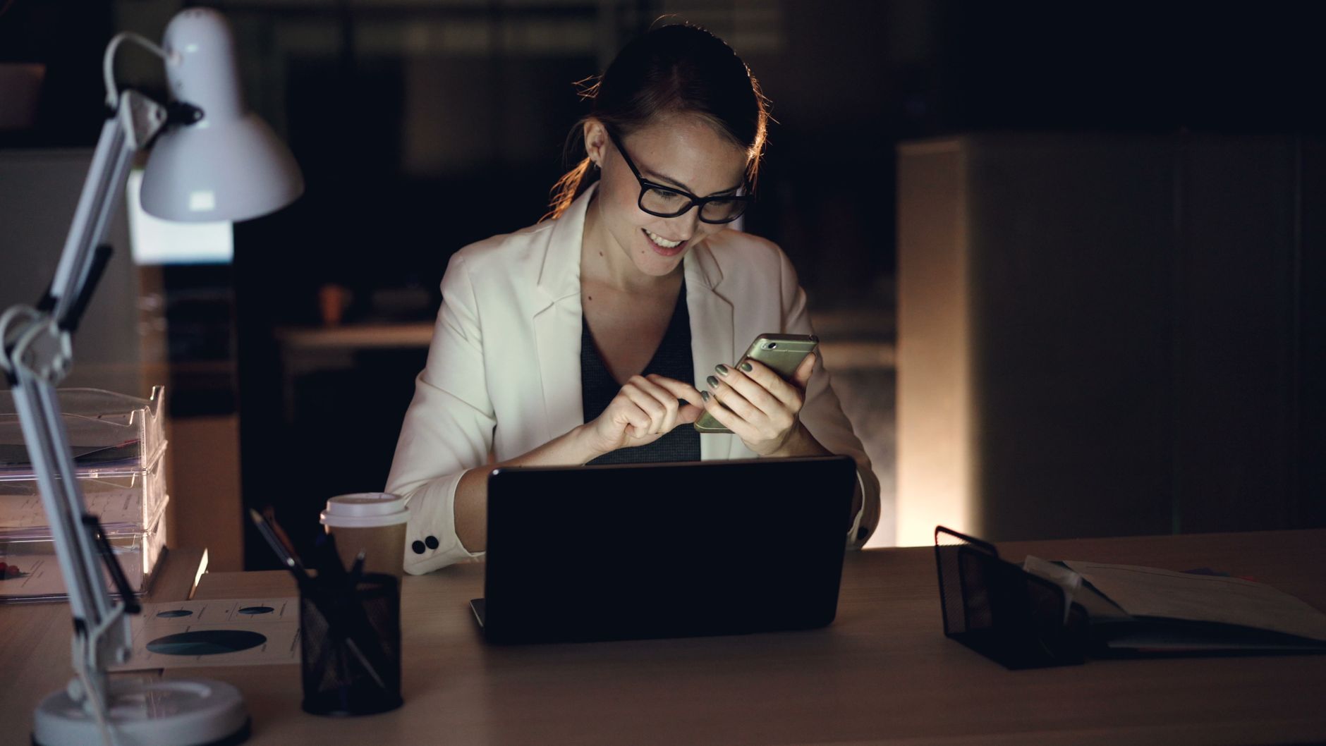businesswoman using smartphone in office at night